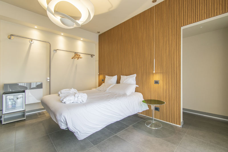Camera matrimoniale con minibar e parete in legno a doghe — Camera ADA, Esse Elegant House