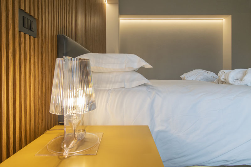Comodino giallo con lampada accanto al letto sospeso — Suite SILVIA, Esse Elegant House