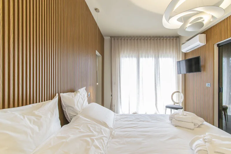 Camera matrimoniale con parete in legno e aria condizionata — Camera ADA, Esse Elegant House