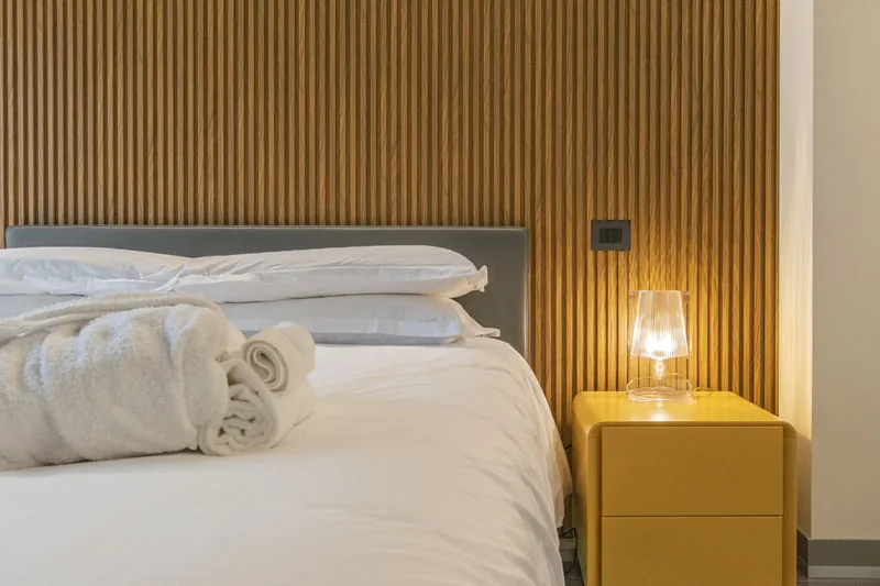 Letto sospeso con asciugamani arrotolati e lampada accesa